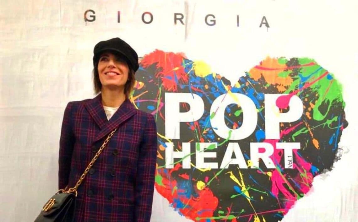 Un ritratto di Giorgia di fronte all'immagine di copertina dell'album "Pop Heart", in cui l'artista ha preferito seguire il cuore invece che la ragione