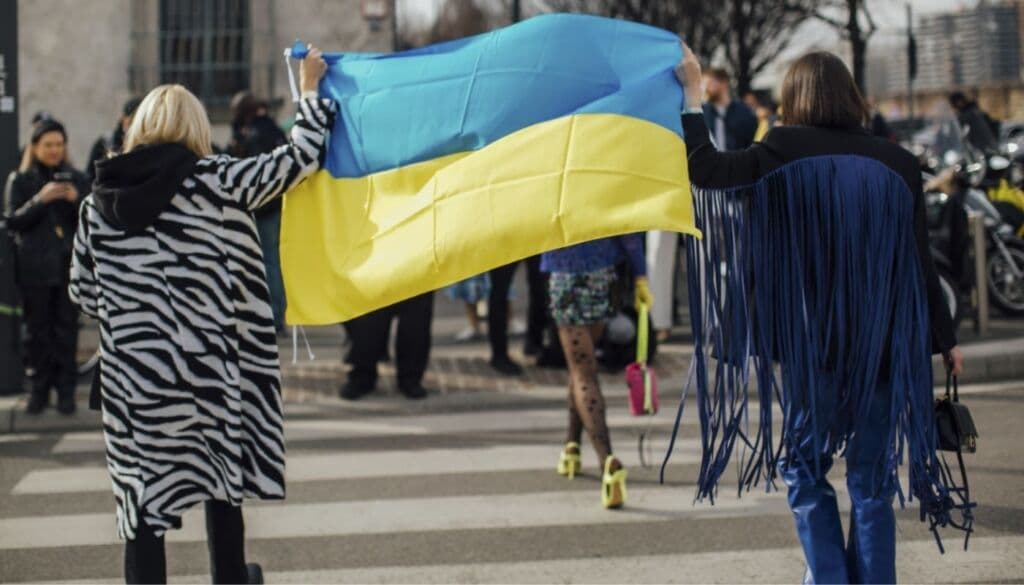 manifestanti durante la milano fashion week con la bandiera ucraina